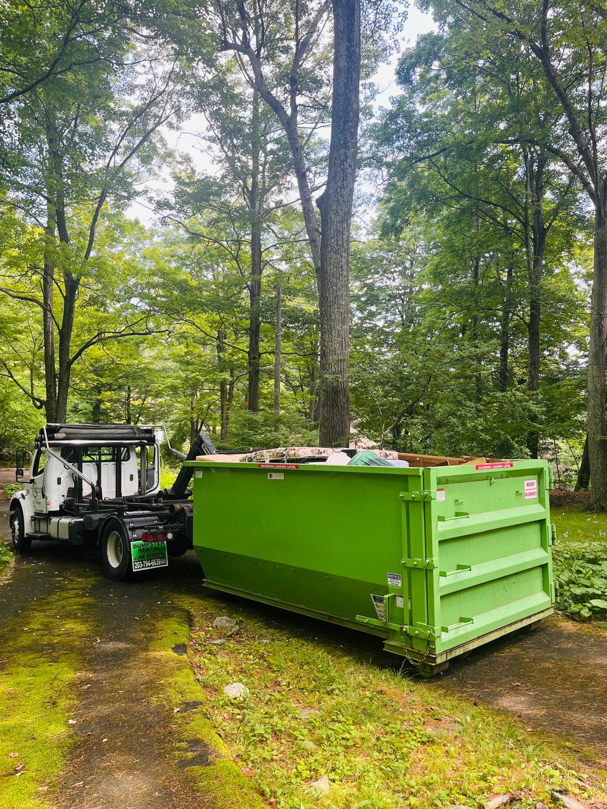 Dumpster pickup in wooded setting