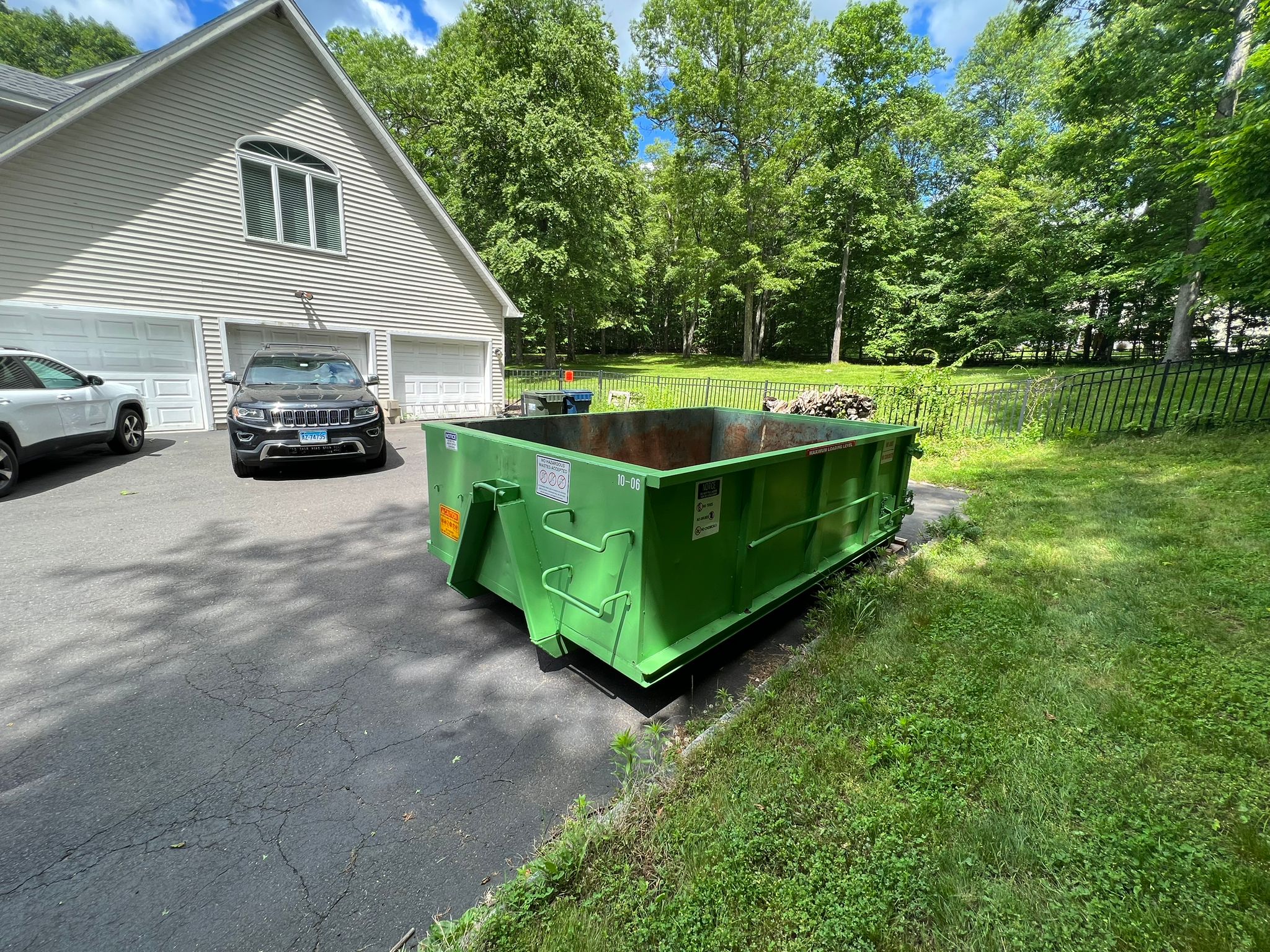 Dumpster placed on driveway with board protection
