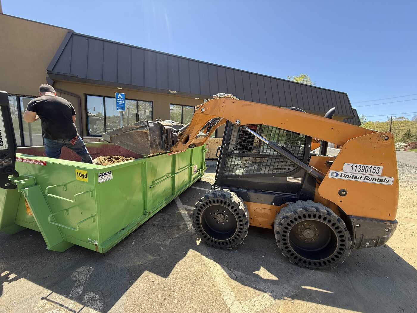 Loading a dumpster with a skidsteer on-site